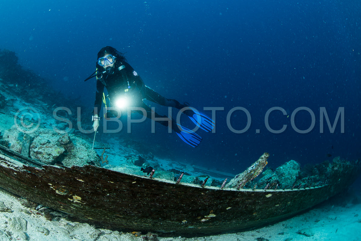 Photo de Plongeur sur l'épave en bois d'un bateau de plongée avec bouteilles à Maratua