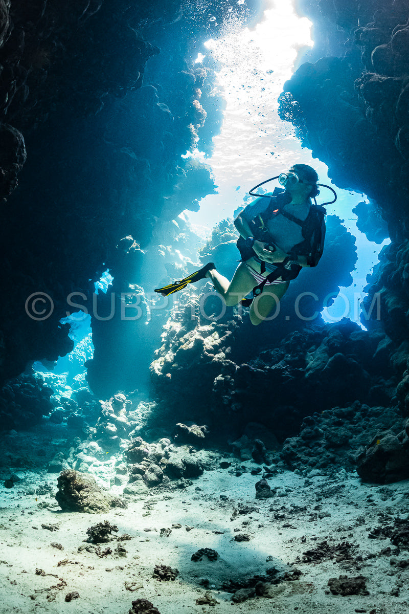 Photo de Femme plongeuse visitant une grotte sous-marine dans la mer rouge - Égypte - Shaab Claude