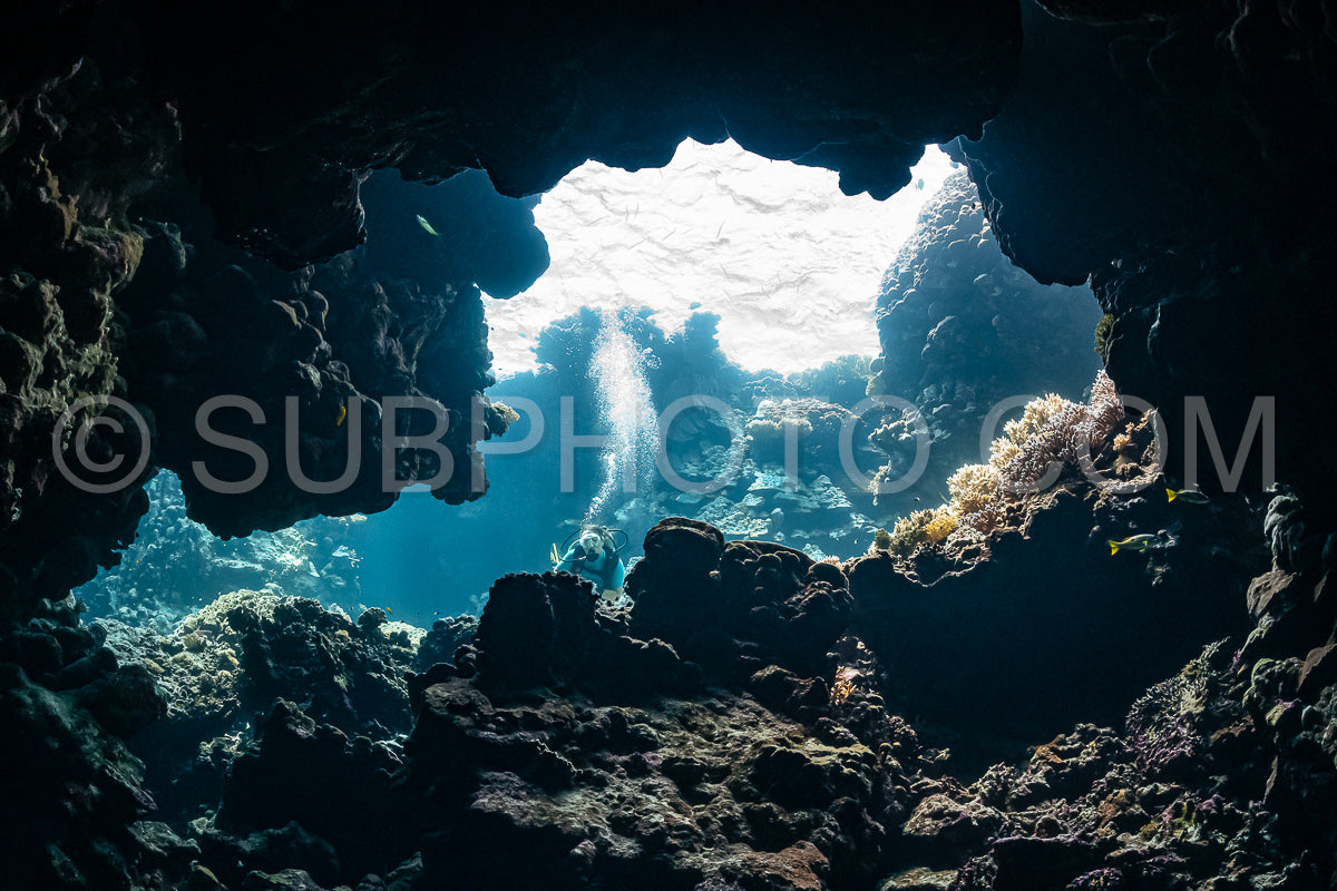 Photo de Femme plongeuse visitant une grotte sous-marine dans la mer rouge - Égypte - Shaab Claude