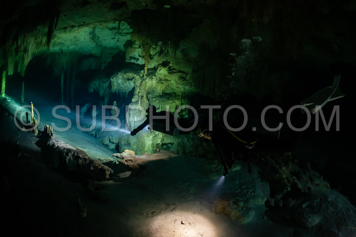 Photo de instructeur de plongée spéléo dirigeant un groupe de plongeurs dans un cenote mexicain sous l'eau