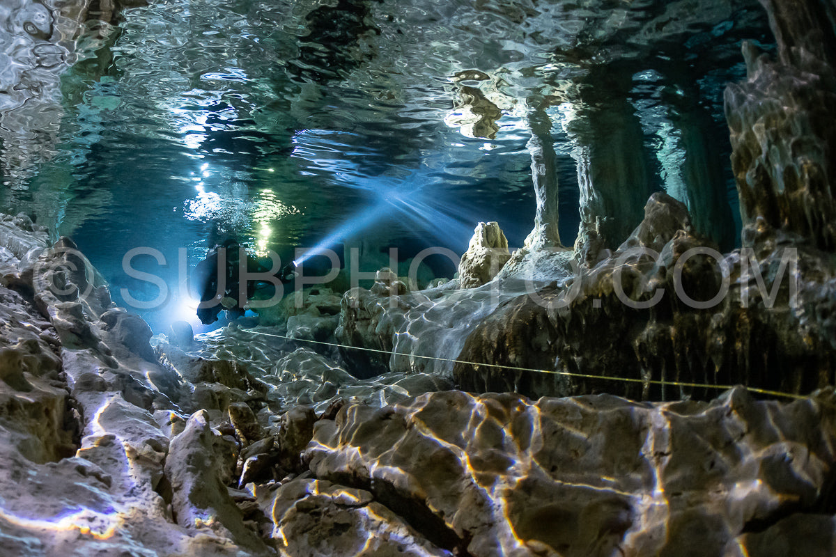 Photo de instructeur de plongée spéléo dirigeant un groupe de plongeurs dans un cenote mexicain sous l'eau