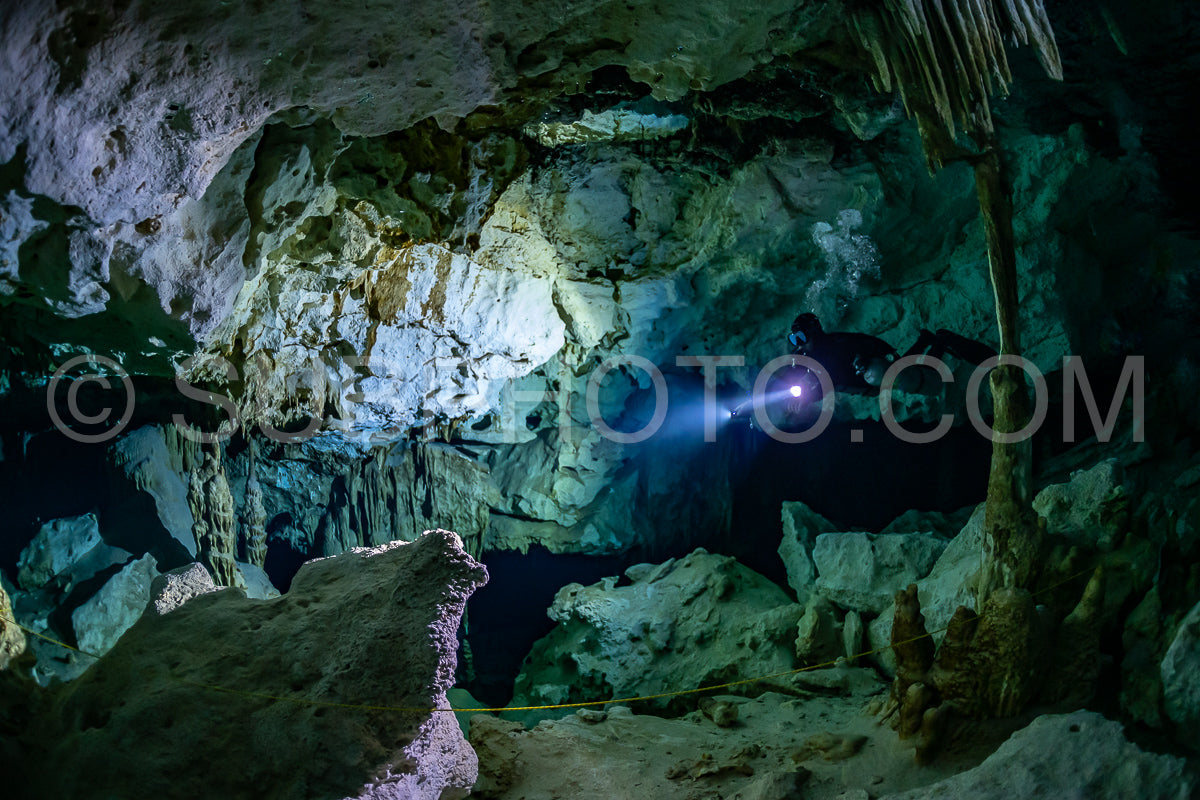 cave diver instructor leading a group of divers in a mexican cenote underwater