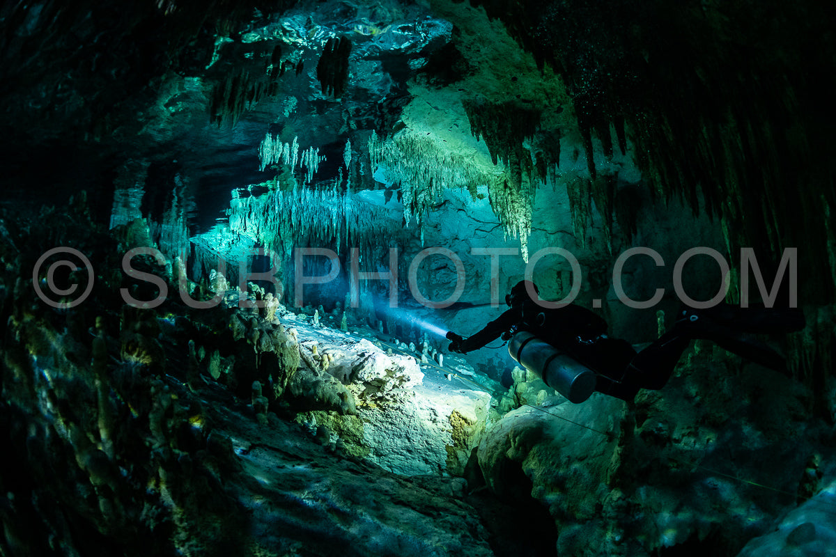 Photo de instructeur de plongée spéléo dirigeant un groupe de plongeurs dans un cenote mexicain sous l'eau