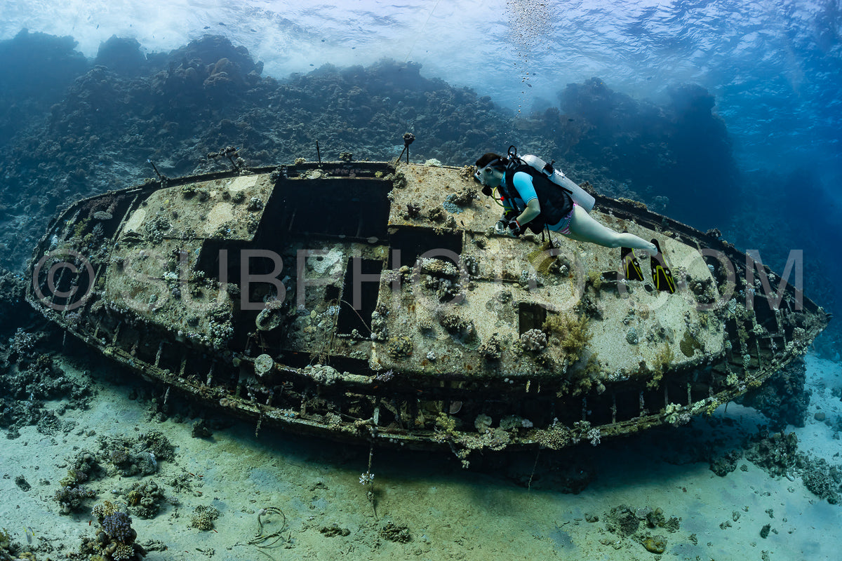 Photo de Femme plongeuse visitant l'épave d'un voilier en métal sur un récif de la mer de Réa - Égypte