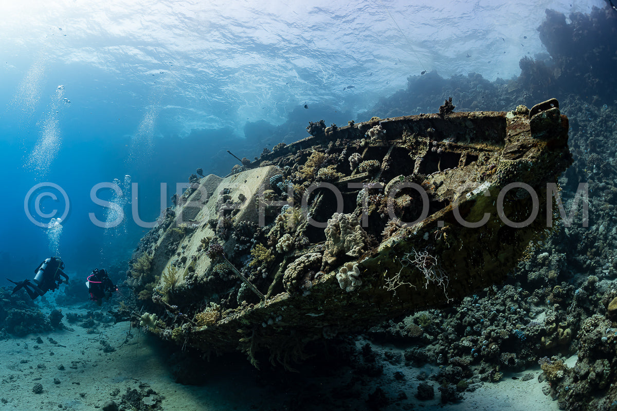 Photo de plongeurs visitant l'épave sous-marine d'un voilier en métal sur un récif de la mer de Rea - Égypte