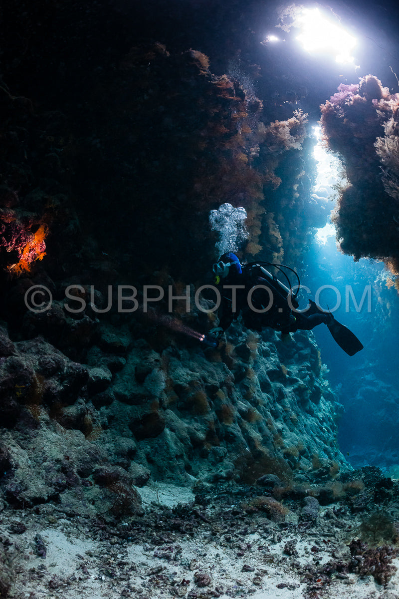 Photo de grotte sous-marine typique dans un récif de mer rouge avec un plongeur photographe sous-marin