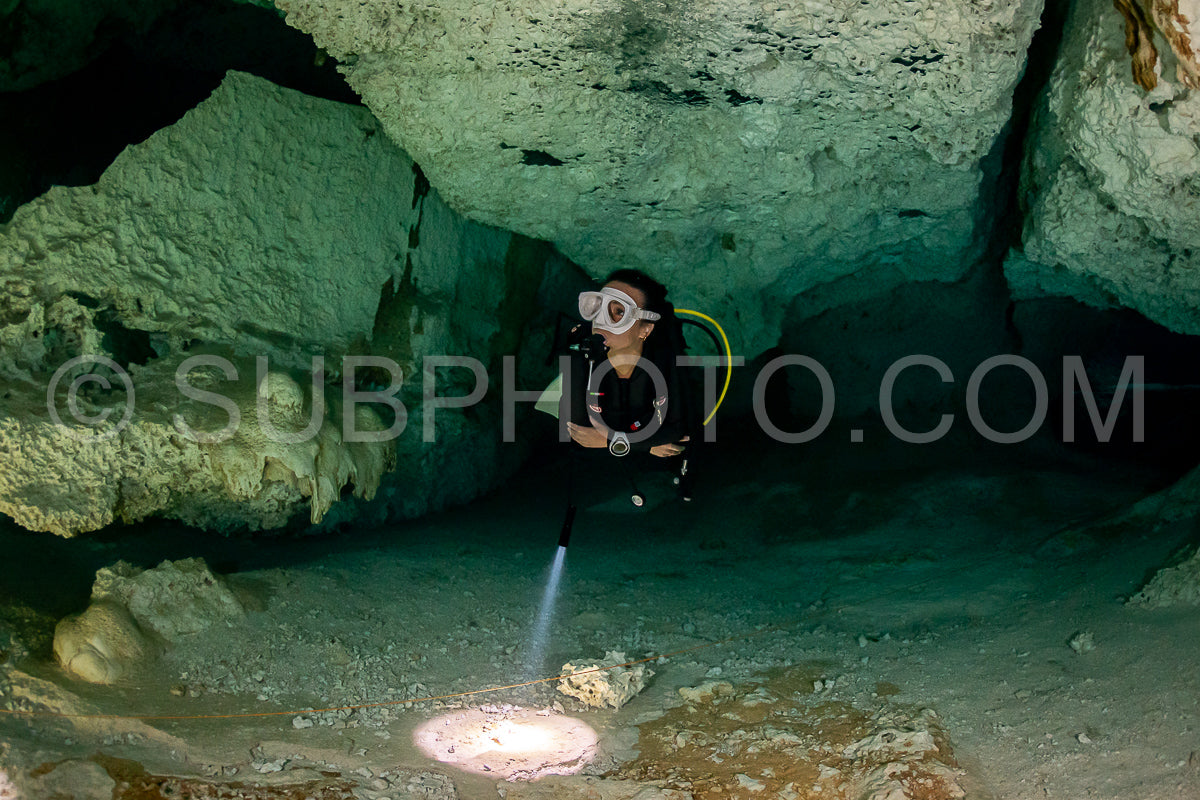 Photo de instructeur de plongée spéléo dirigeant un groupe de plongeurs dans un cenote mexicain sous l'eau