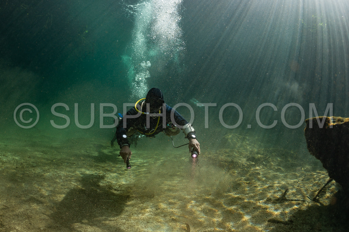 Photo de instructeur de plongée spéléo dirigeant un groupe de plongeurs dans un cenote mexicain sous l'eau