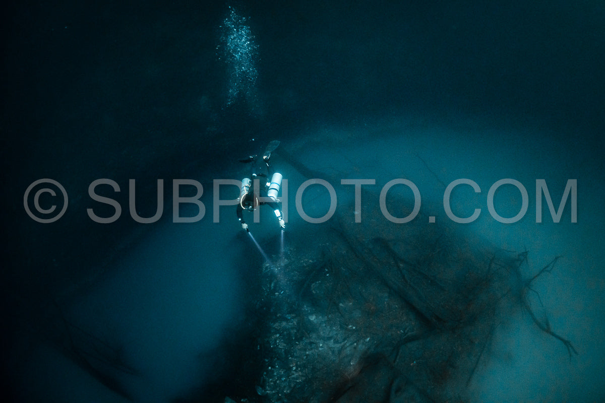 cave diver instructor leading a group of divers in a mexican cenote underwater