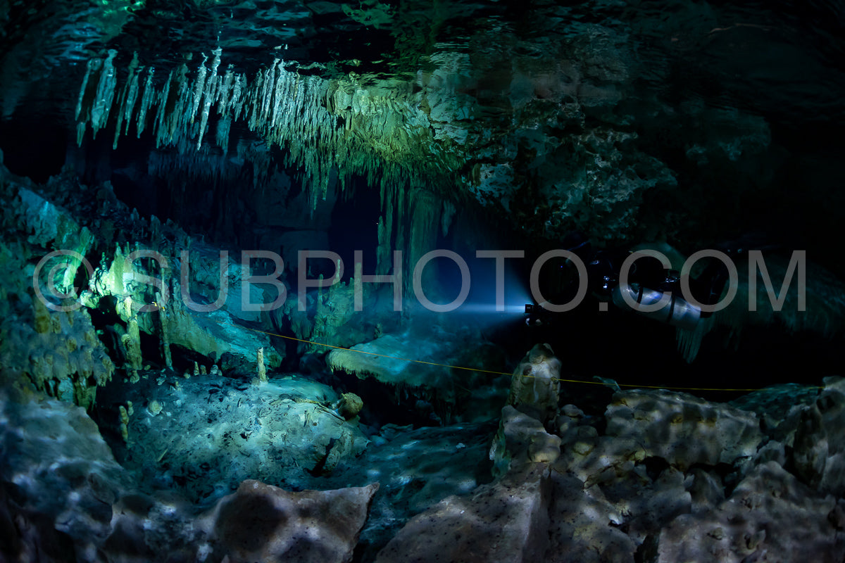 Photo de instructeur de plongée spéléo dirigeant un groupe de plongeurs dans un cenote mexicain sous l'eau