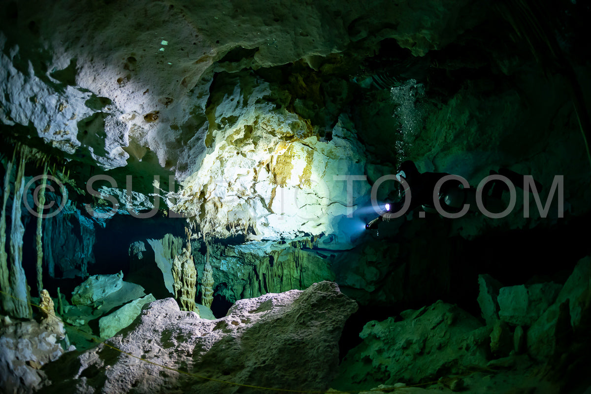 Photo de instructeur de plongée spéléo dirigeant un groupe de plongeurs dans un cenote mexicain sous l'eau