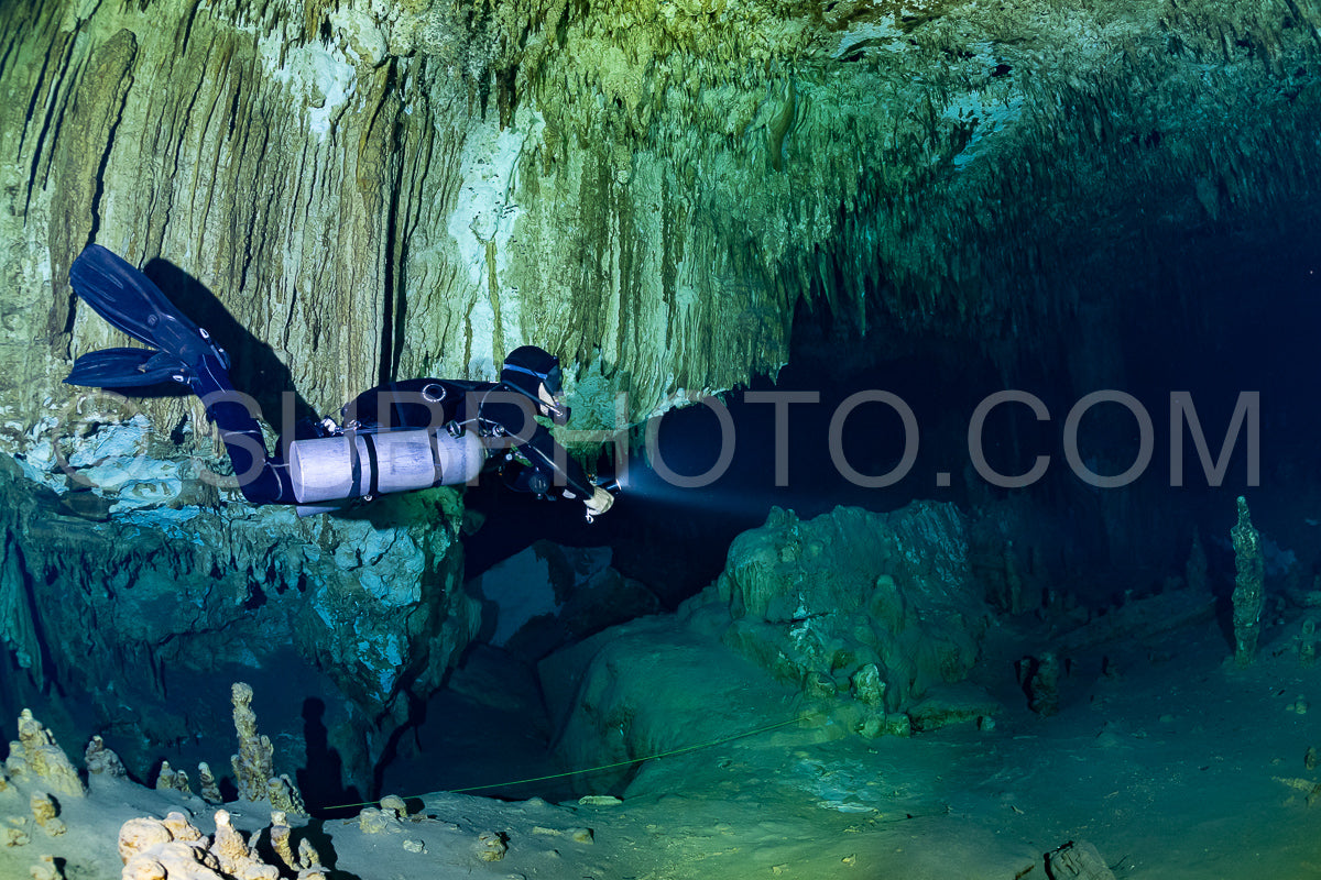 Photo de instructeur de plongée spéléo dirigeant un groupe de plongeurs dans un cenote mexicain sous l'eau