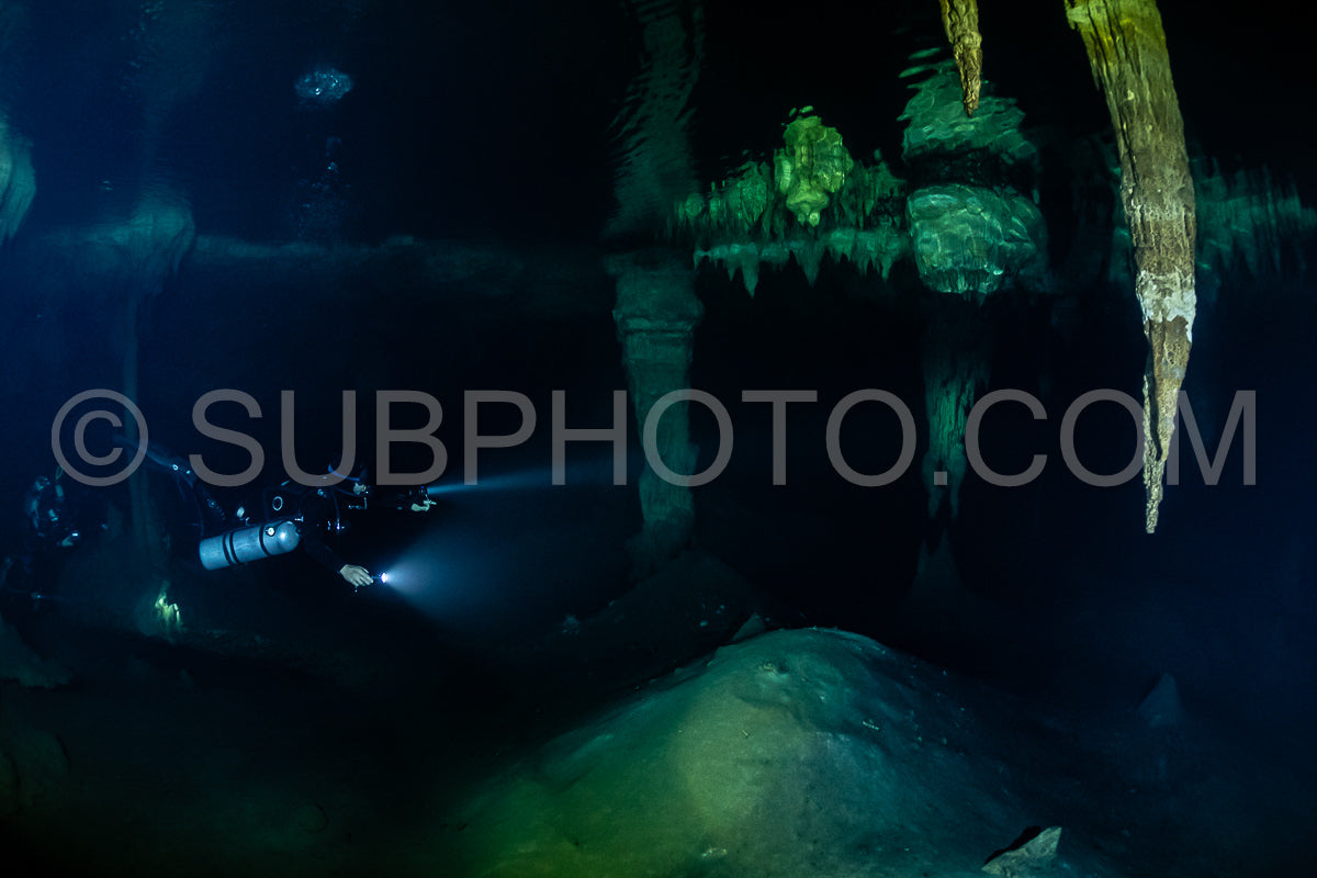 Photo de instructeur de plongée spéléo dirigeant un groupe de plongeurs dans un cenote mexicain sous l'eau